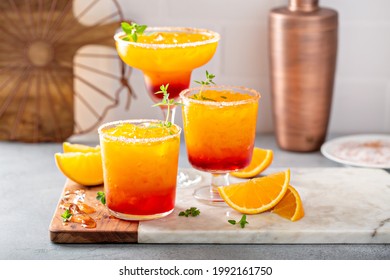 Tequila sunrise margarita cocktail in different glasses with ice, refreshing summer drink