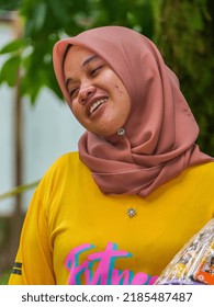 Terengganu, Malaysia - August 02, 2022: Potrait image of a smilling malay woman with yellow shirt.