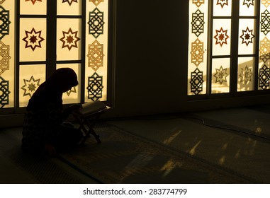 TERENGGANU, MALAYSIA-MAY 2015: Muslim woman reading Koran alone in the evening at Mukhtafi Bilal Shah Mosque on MAY, 2015 in Mukthafi Bilal Shah Town, Terengganu.