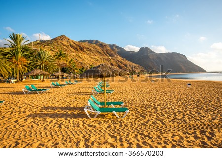Teresitas beach with sunbeds and mountains on the background on the sunset on Tenerife island, Spain