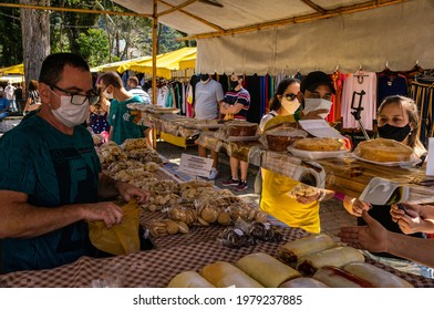 TERESOPOLIS, RIO DE JANEIRO - BRAZIL: AUG 15, 2020: A food stall tent with lots of cookies, cakes and sweets for sale with costumers in Alto Fair located on Higino da Silveira square, Alto district.