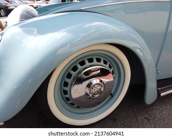 Teresopolis, RJ, Brazil - March 20th 2022 - Wheel and tyre of a Volkswagen Beetle. Light blue color. Tyre with a white strip. Chrome hubcap. Vintage old classic car.