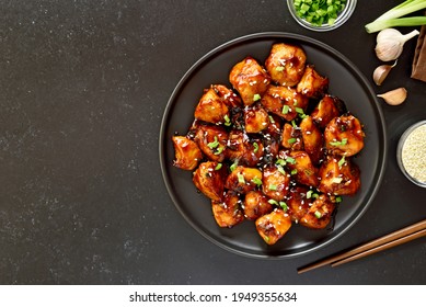 Teriyaki Chicken On Plate Over Black Stone Background With Free Text Space. Top View, Flat Lay
