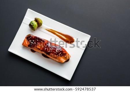 Teriyaki salmon from above. Japanese cuisine inspired dinner consisting of a grilled salmon fillet glazed in delicious teriyaki sauce (soy sauce base). Healthy brussel sprouts as sides.