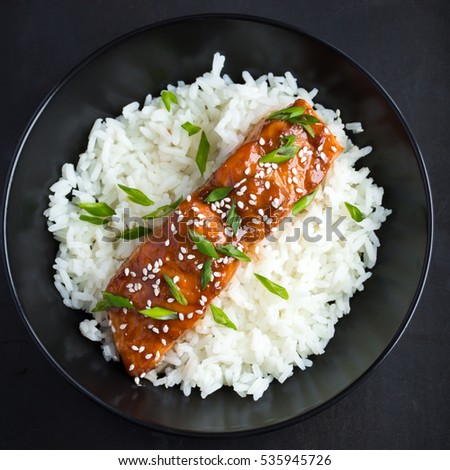 teriyaki salmon and  rice, served with sesame seeds and chopped green onions, top view.