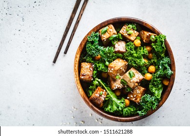 Teriyaki tofu salad with kale and chickpeas in wooden bowl. - Shutterstock ID 1511621288