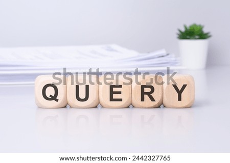 the term 'query' is inscribed on wooden blocks, with a potted plant visible in the background