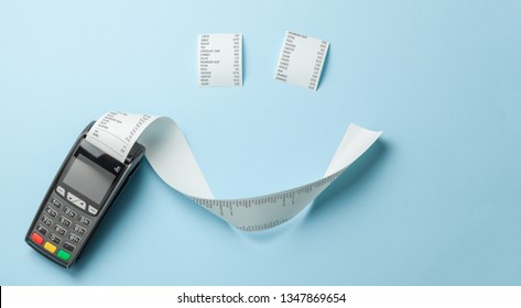 Terminal cash register machine POS for payments and long roll paper cash tape in the shape of smile on blue background - Shutterstock ID 1347869654