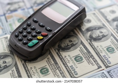 Terminal for cashless payments. Concept - refusal of cash transactions. Hundred dollar bills near cash register terminal. Concept - sale equipment for working with bank cards. Payment upon purchase - Powered by Shutterstock