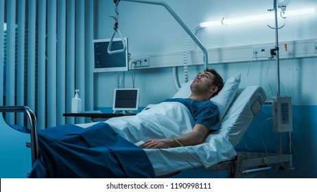 Terminally Ill Male Patient Lies On A Bad In The Hospital. Melancholy And Exhausted Patient In The Palliative Care Ward.