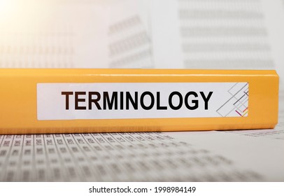 Terminology word on bright yellow office folder on financial documents. Concept of terms in finance, business and accounting.