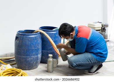 Termite Control Workers Are Preparing A Liquid Termite Exterminator To Be Injected Into The Termite Pipe Under The Ground Of The House.