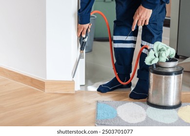 Termite extermination, exterminators outdoors in work wear spraying pesticide with sprayer - Powered by Shutterstock