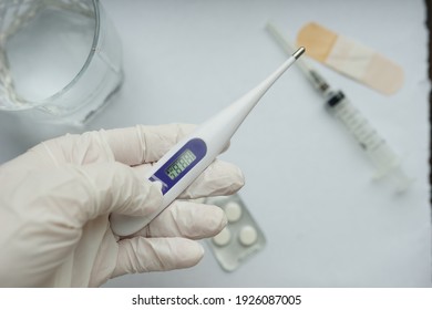 termometer in doctor's arms on medical background 