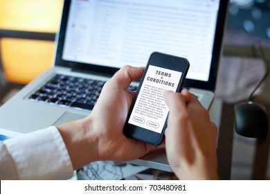 terms and conditions, man reading agreement on the screen of smartphone