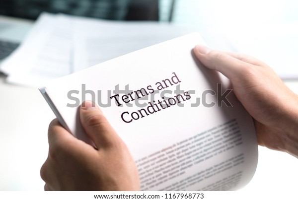 Terms and conditions text in legal agreement\
or document about service, insurance or loan policy. Lawyer or\
client holding contract paper in\
office.