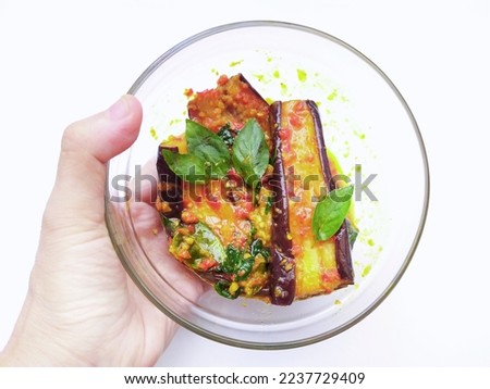 Terong Balado in a woman's hand on a white background