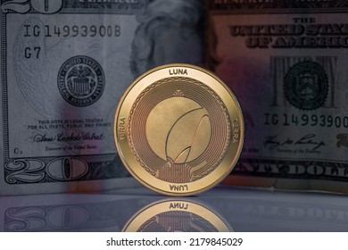 Terra Luna LUNC Cryptocurrency Physical Coin Placed on reflective surface with twenty dollar bill behind. - Shutterstock ID 2179845029