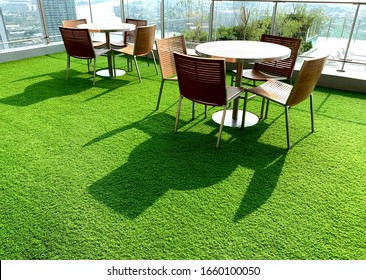 Terrace, Cushion made of fabric and furniture outdoor table set. Placed on an artificial green grass, table set for dining decorating with artificial grass circle shape on the floor.