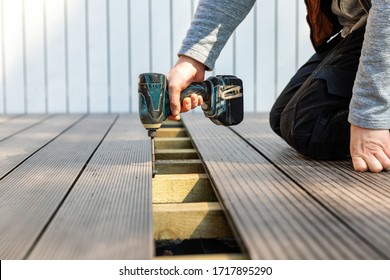 terrace deck construction - man installing wpc composite decking boards - Shutterstock ID 1717895290