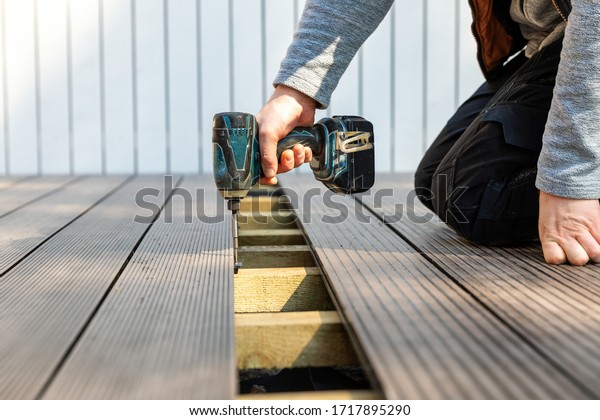 terrace deck construction - man installing wpc\
composite decking\
boards