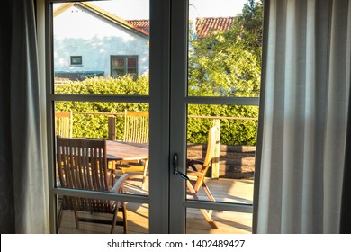 Terrace with a dining table is ready for breakfast. Sunrise above the garden is a beautiful start of the day. - Powered by Shutterstock