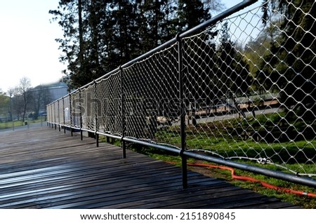 Terrace fencing, railings of metal pipes filled with steel cables cable mesh. fencing wire stainless steel fence. wooden floor, dance floor in the park