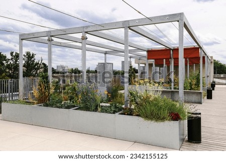Terrace Garden on Roof Building. Roof Patio Garden with Modern Pergola Awning and Greenery. Urban Relax Zone on Public Veranda on Roof House. 
