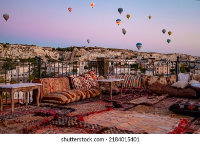 Terrace Of Hotel In Goreme Cappadocia And Hot Air Balloons Rising Into Sky, Concept  Of Must See Travel Destination, Bucket List Trip