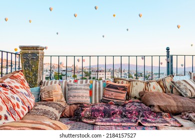 Terrace Of Hotel In Goreme Cappadocia And Hot Air Balloons Rising Into Sky, Concept  Of Must See Travel Destination, Bucket List Trip