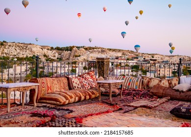 Terrace Of Hotel In Goreme Cappadocia And Hot Air Balloons Rising Into Sky, Concept  Of Must See Travel Destination, Bucket List Trip