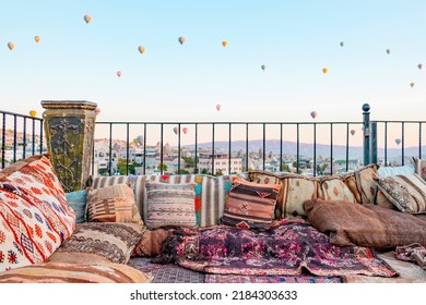 Terrace Of Hotel In Goreme Cappadocia And Hot Air Balloons Rising Into Sky, Concept  Of Must See Travel Destination, Bucket List Trip