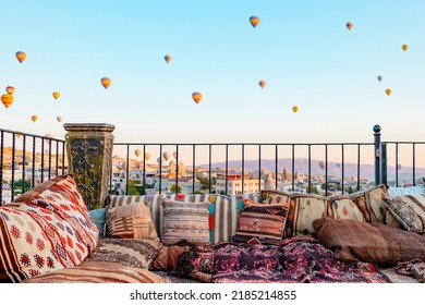 Terrace Of Hotel In Goreme Cappadocia And Hot Air Balloons Rising Into Sky, Concept  Of Must See Travel Destination, Bucket List Trip