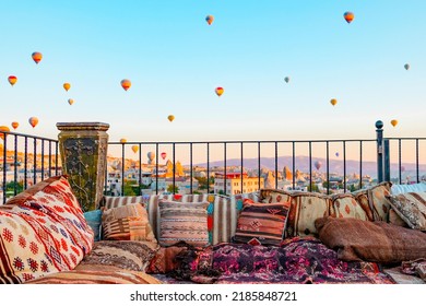 Terrace Of Hotel In Goreme Cappadocia And Hot Air Balloons Rising Into Sky, Concept  Of Must See Travel Destination, Bucket List Trip