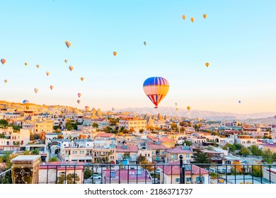 Terrace Of Hotel In Goreme Cappadocia And Hot Air Balloons Rising Into Sky, Concept  Of Must See Travel Destination, Bucket List Trip