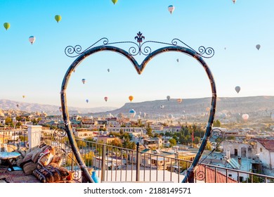 Terrace Of Hotel In Goreme Cappadocia And Hot Air Balloons Rising Into Sky, Concept  Of Must See Travel Destination, Bucket List Trip