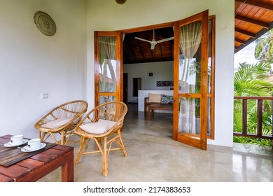 Terrace Of Hotel Room Or Home, Interior In Indian Style. Inside Bungalow On Tropical Beach. Coffee Cups, Wicker Chairs And Palm Trees View In House Apartment. Tangalle, Sri Lanka - Nov 1, 2017