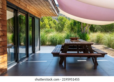 Terrace Table On The Porch Of A Country House With An Awning Covering It From The Sun.