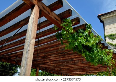 terrace with wooden pergola and plexiglass roof. vines are straining, crawling under the beams. garden or park. sitting with dry wall wine region. restaurant countryside france - Shutterstock ID 2173574573