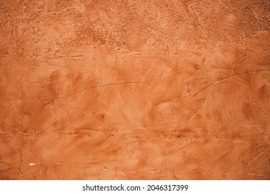 Terracotta colored plaster wall, rustic background or texture 