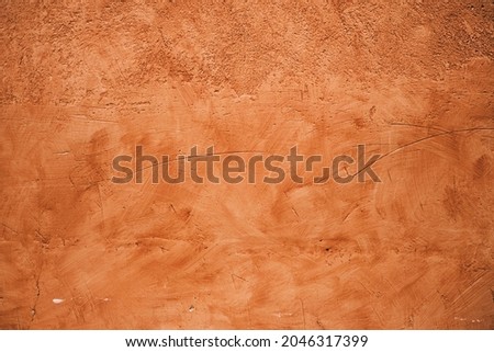 Terracotta colored plaster wall, rustic background or texture 
