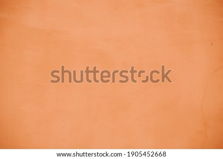 Terracotta or peach colored plastered wall. Design element, background, texture. 