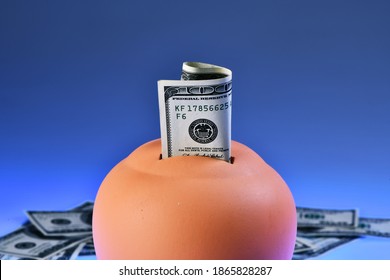 Terracotta Piggy Bank - Money Box - Isolated On Blue Background And Dollars. Saving 100 US Dollar Bill In A Piggy-bank. Money Saving