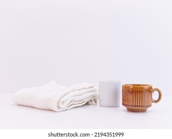 Terracotta Small Coffee Cup And White Kitchen Cloth On A White Table With Copy Space