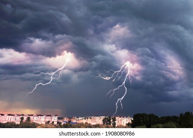 A terrible dangerous storm with a strong wind swirls thunderclouds in the mountains with fabulous twists, from which rain and hail or a thunderstorm with lightning flies. - Shutterstock ID 1908080986