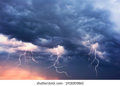 A terrible dangerous storm with a strong wind swirls thunderclouds in the mountains with fabulous twists, from which rain and hail or a thunderstorm with lightning flies.