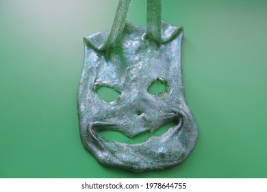 Terrible  Slime Face. Halloween Autumn Holiday Concept. Textured  Green  Slime With Glitter Inside. Macro Of Kids Toy Slime.                 