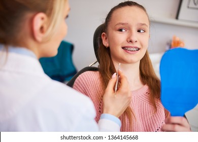 Terrified girl looking at female orthodontist - Powered by Shutterstock