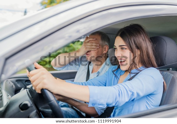 Terrified woman pressing the brake pedal , and\
yells in fear or frustration. Car Accident. Student girl sitting\
scared in a car. incident\
happens