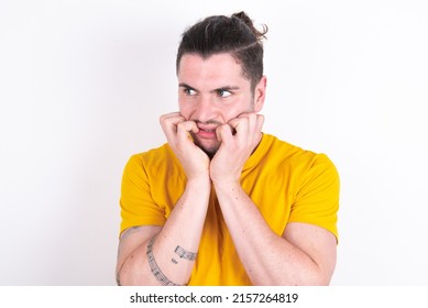 Terrified Young caucasian man wearing yellow t-shirt over white background looks empty space home alone moonless night - Shutterstock ID 2157264819
